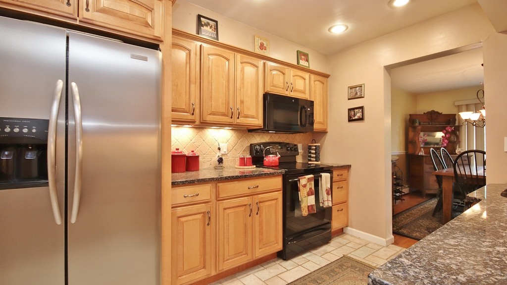 Kitchen has built-in microwave and stainless refrigerator